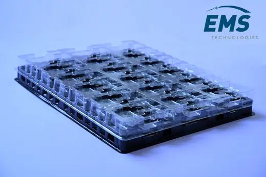 Clear anti-static PET tray of moulded pockets stacked on a black base tray, EMS Technologies