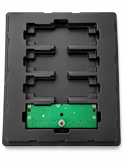 Black thermoformed ESD tray with routed board channels, one populated PCB seated in place, EMS Technologies