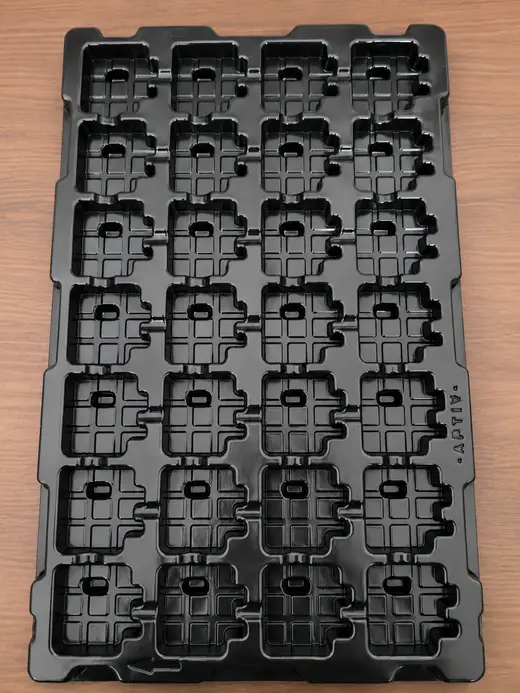 Black thermoformed ESD tray of twenty-eight moulded pockets on a fixed pitch, EMS Technologies